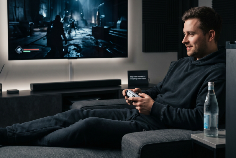 Gamer with chilled bottle in media lounge.