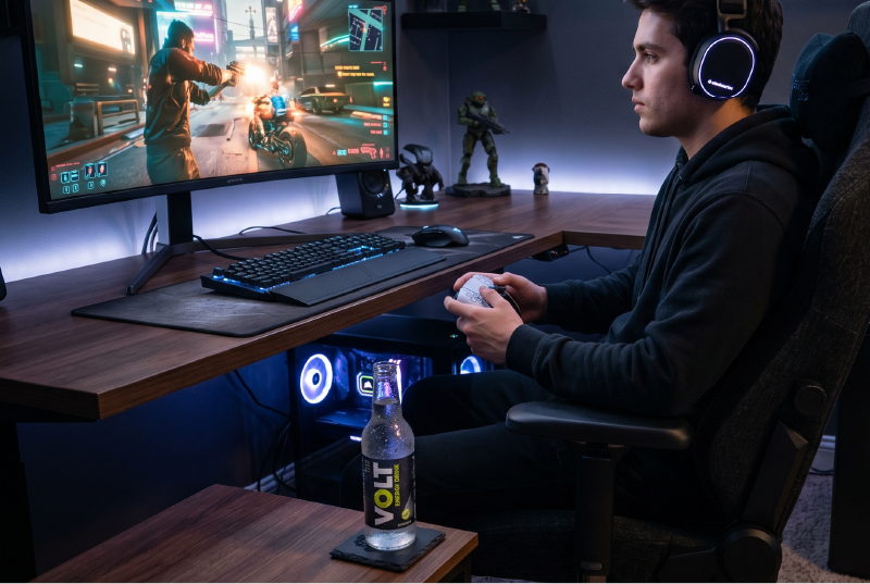 Gamer at desk with chilled energy drink nearby.
